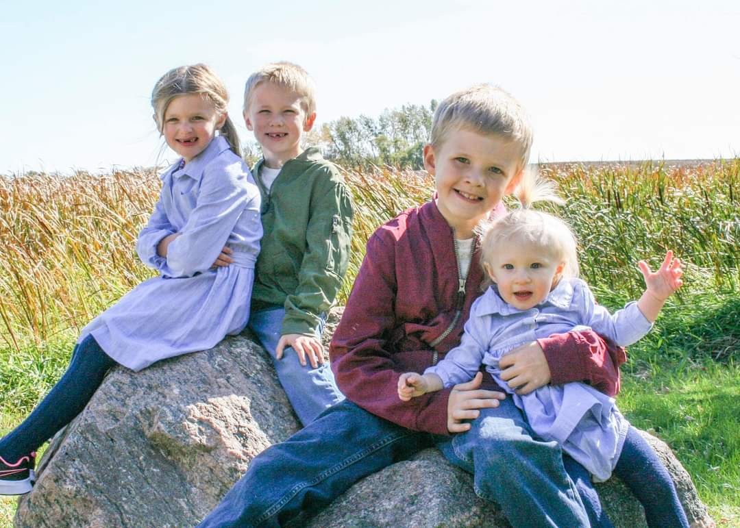 Four children posting together, smiling