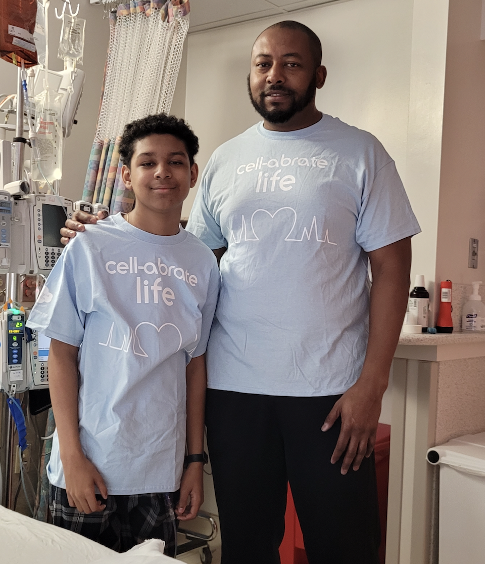 Boy standing with dad, matching shirts that read 